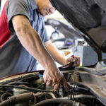 mechanic working under the hood of a car